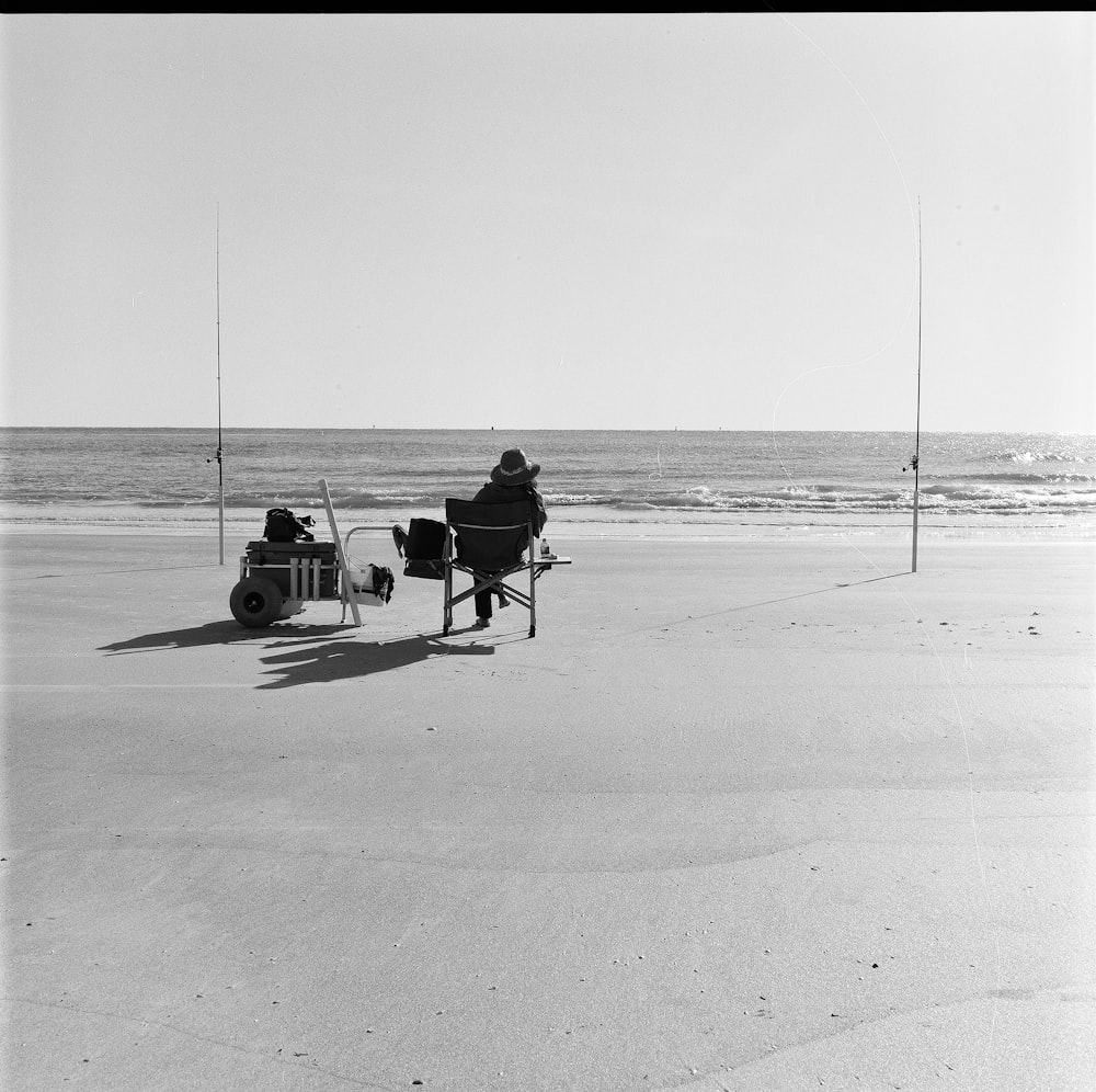 Ein Mann sitzt auf einem Stuhl am Strand