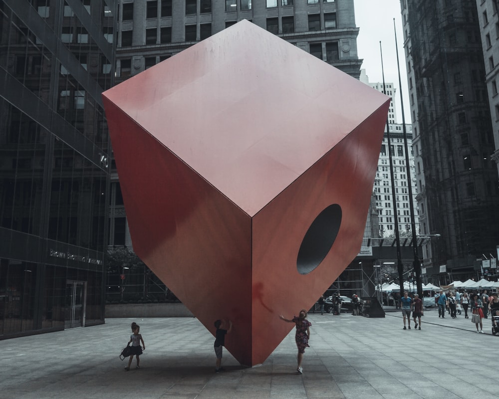 a large red sculpture in front of a building