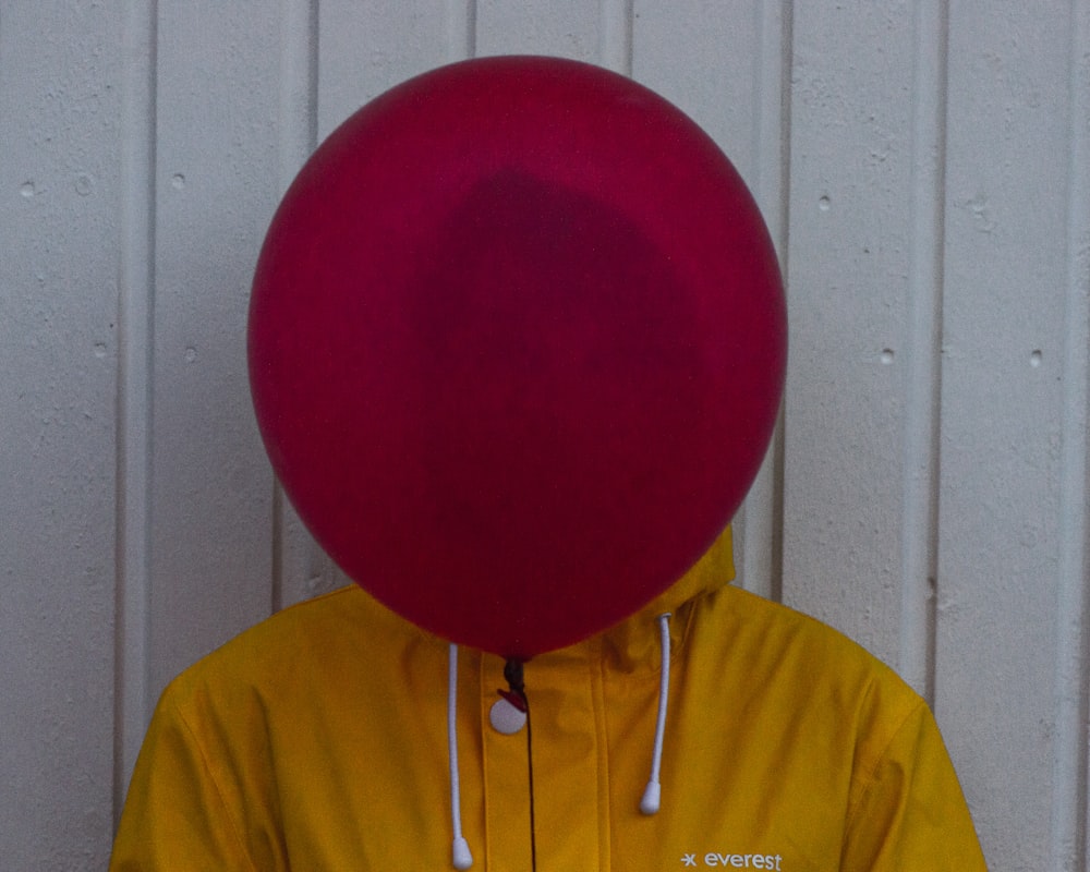 a person wearing a yellow shirt and a red balloon