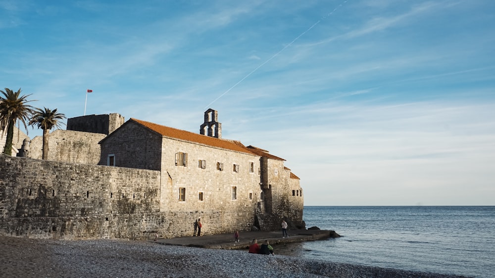 a stone building on a rocky shore