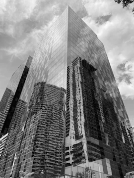 High-rise corporate building with glass panels reflecting the city skyline.