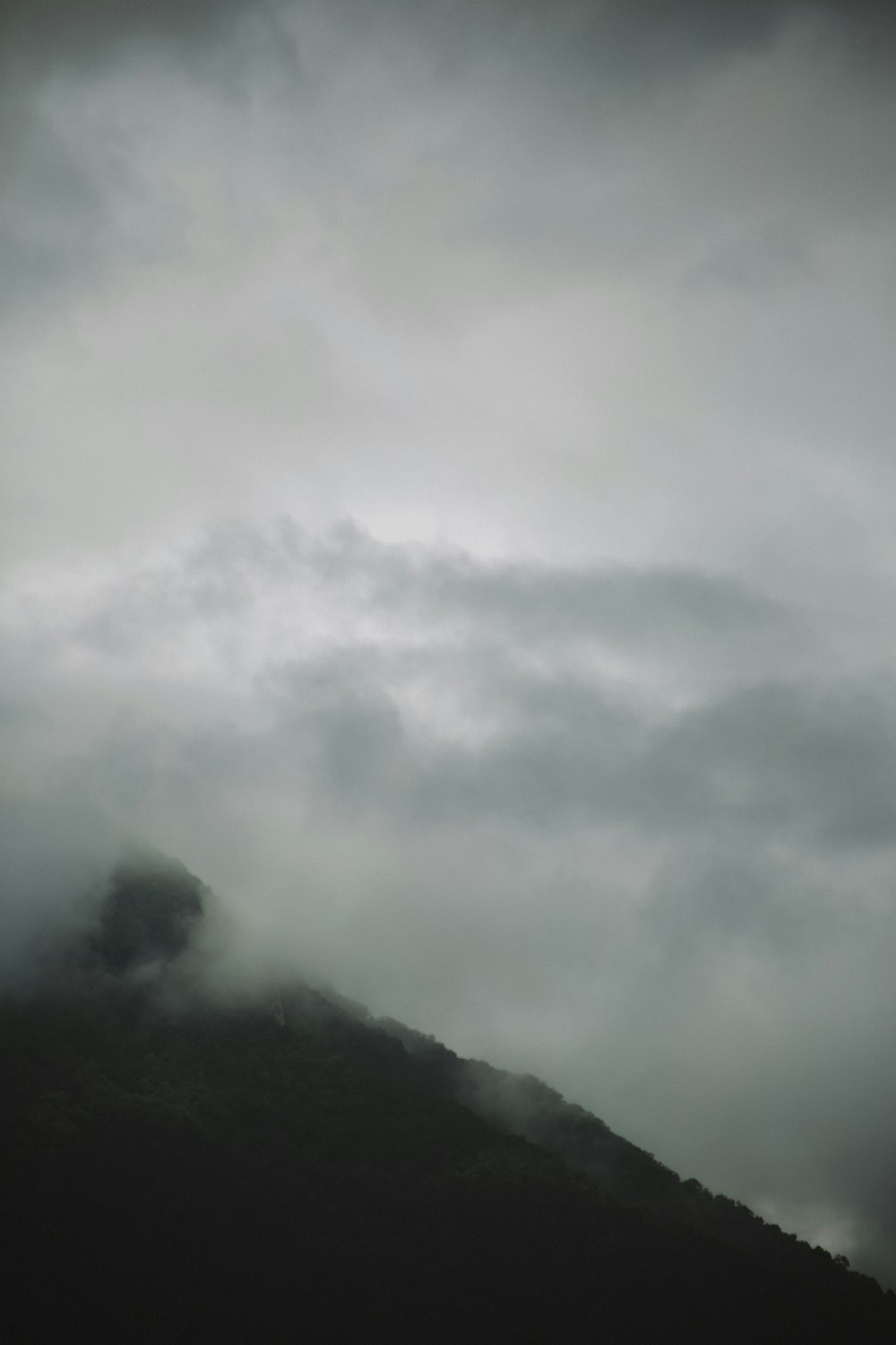 a mountain with clouds above it