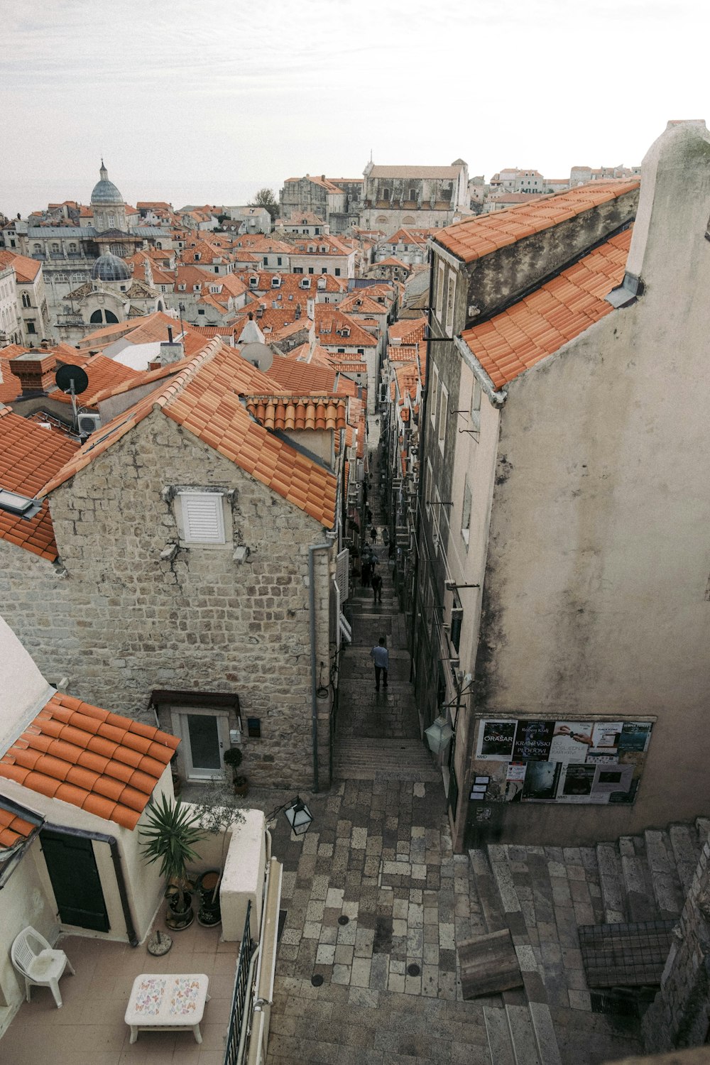 a group of buildings with a person walking on a stone path