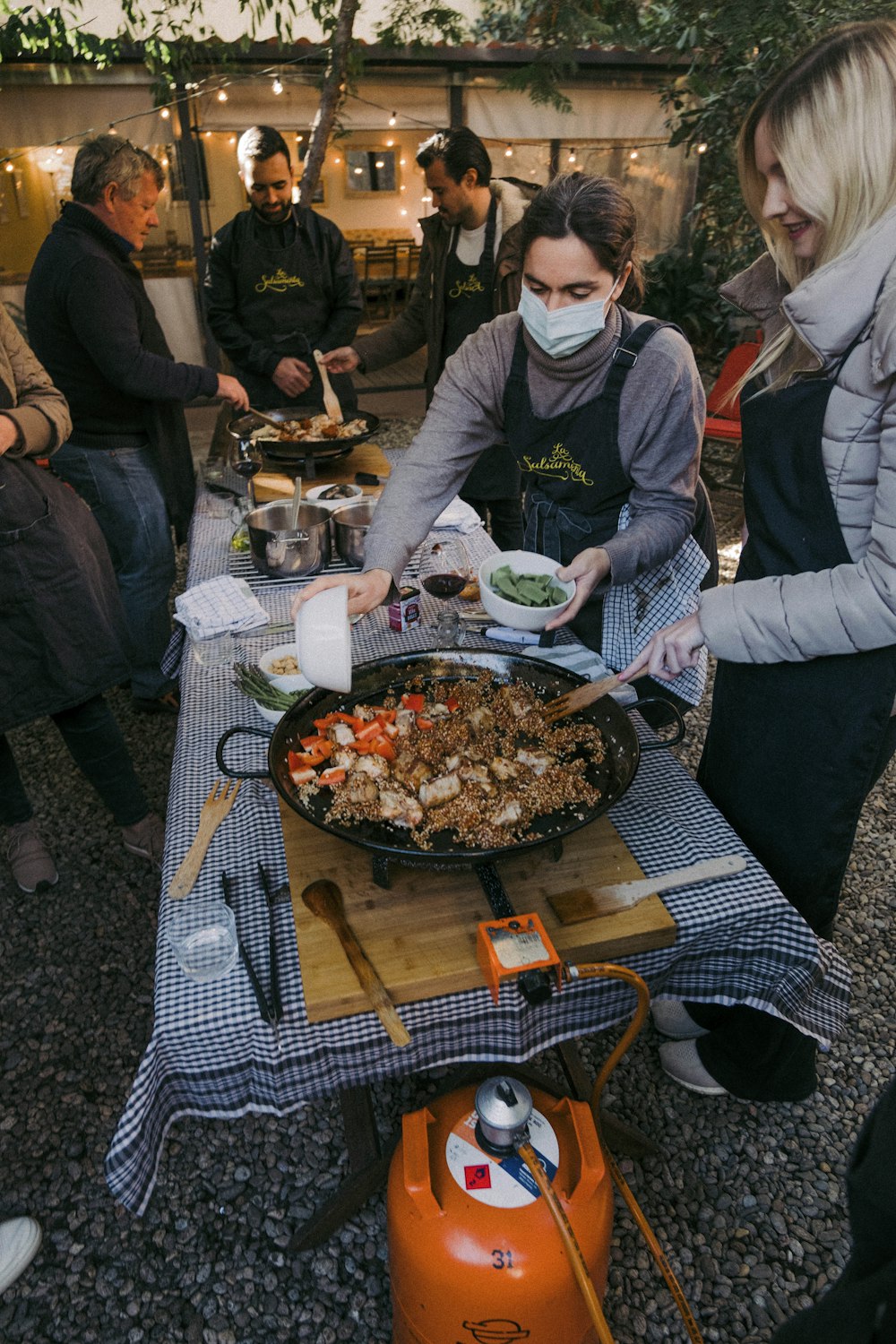 a group of people standing around a table with food on it