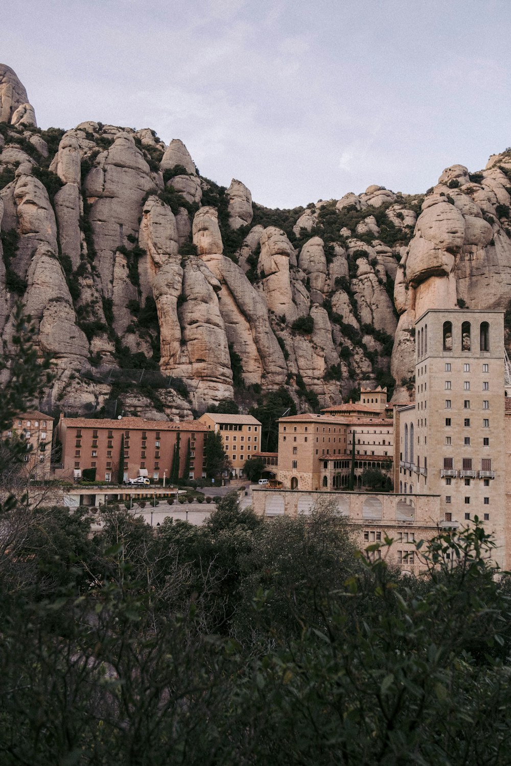 a large rock cliff with buildings below