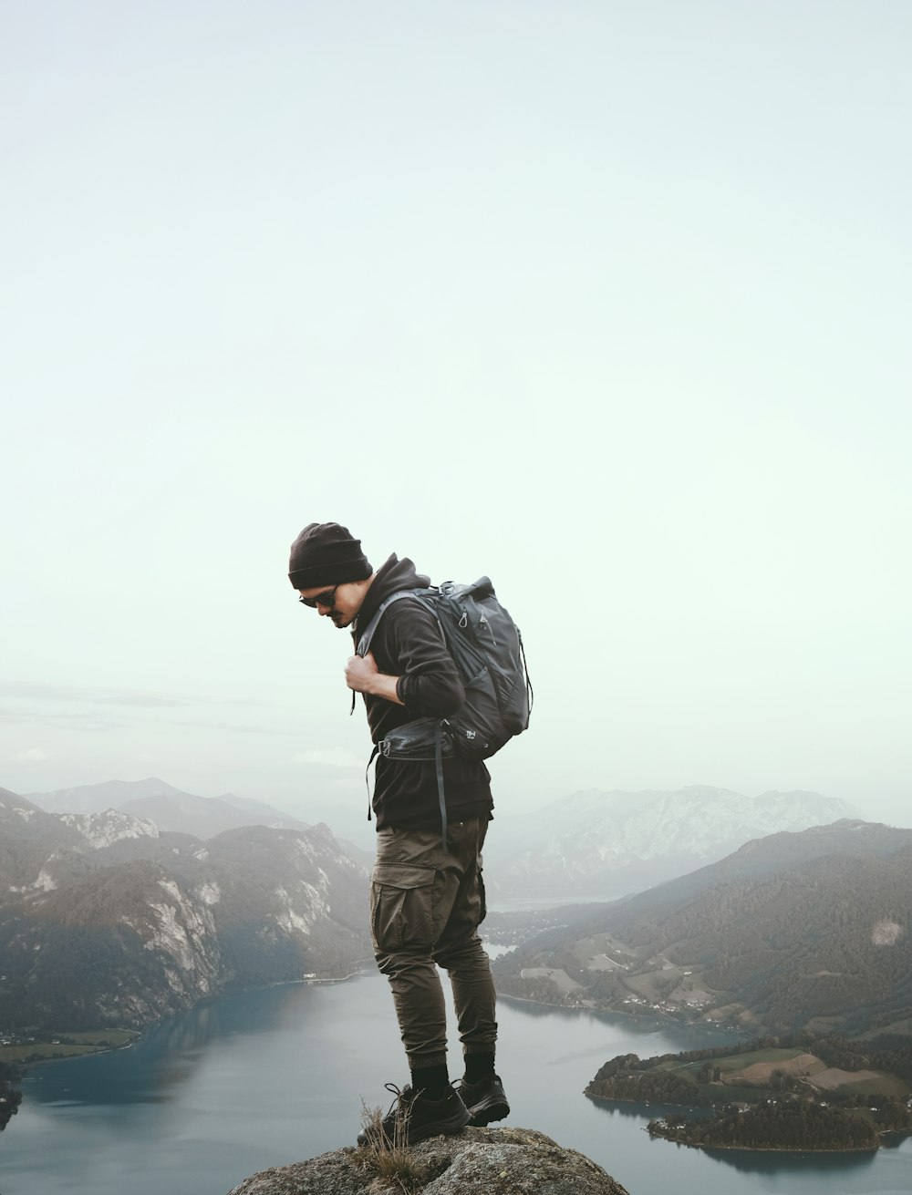 a man standing on a rock overlooking a body of water