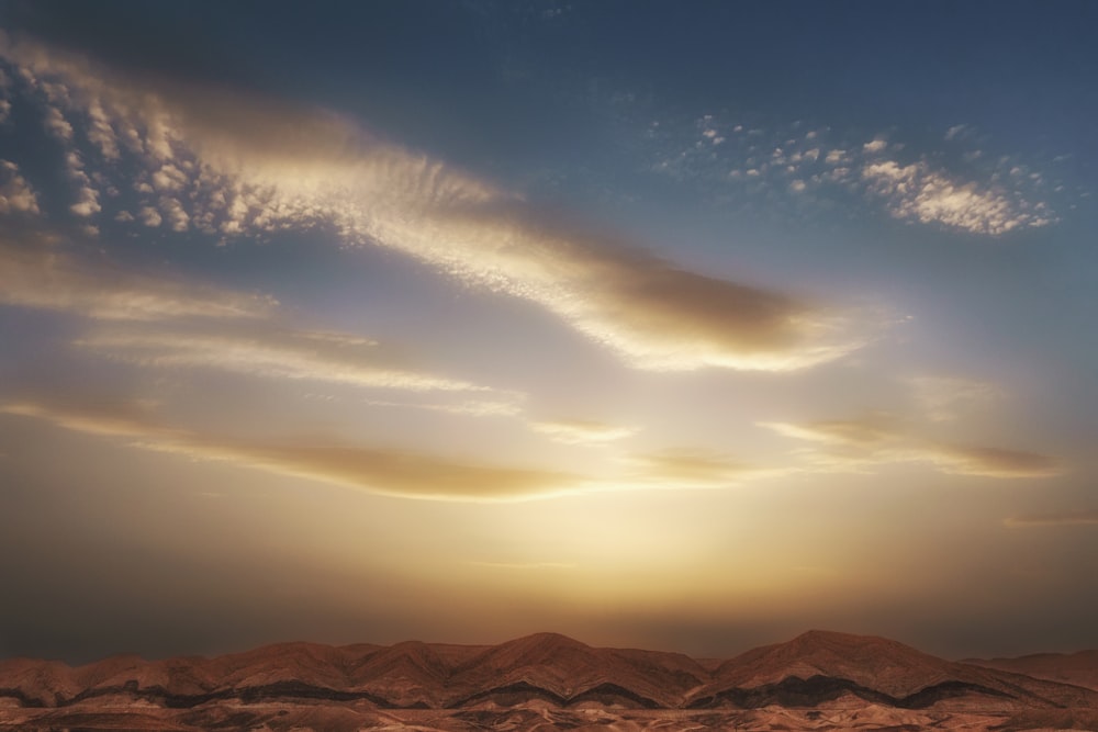 a landscape with mountains and clouds