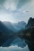 A serene landscape with a calm lake reflecting mountains.