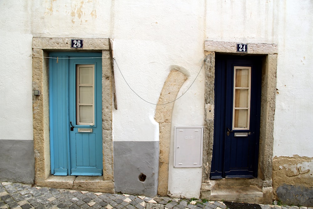 a couple of blue doors on a white building