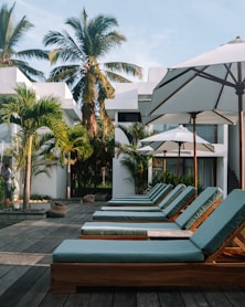 a group of lounge chairs and umbrellas on a patio