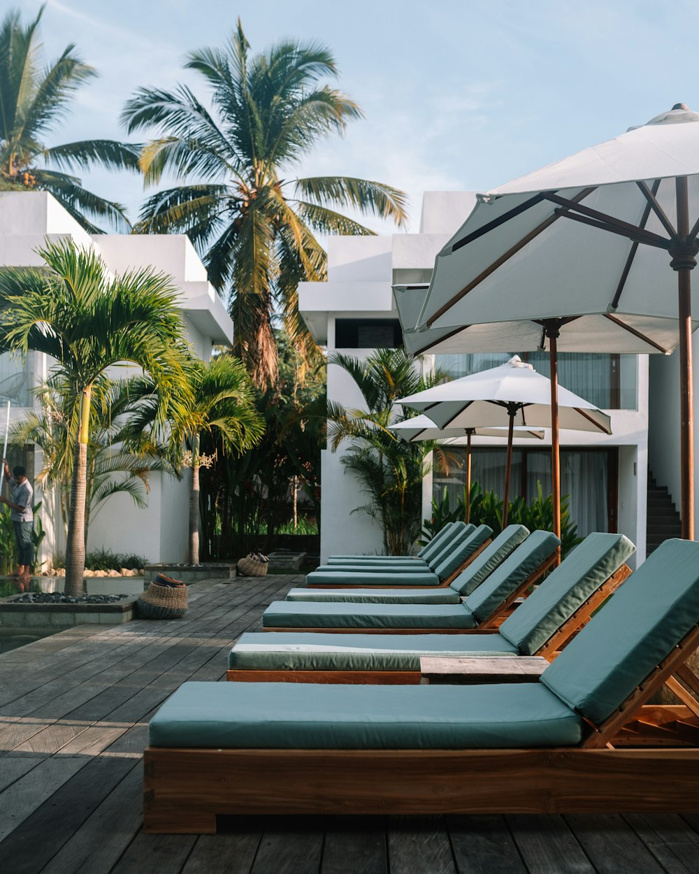 a group of lounge chairs and umbrellas on a patio