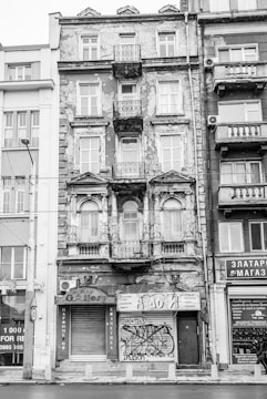 Before and after photos of a renovated building facade with fresh plaster and paint.