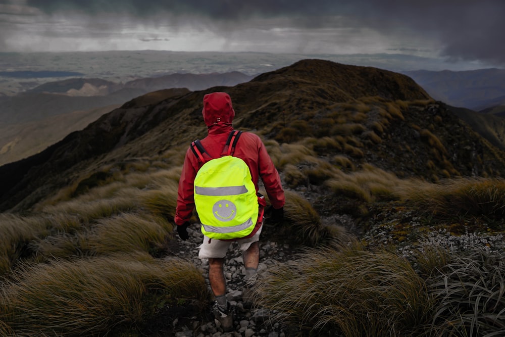 a person wearing a backpack and walking on a mountain