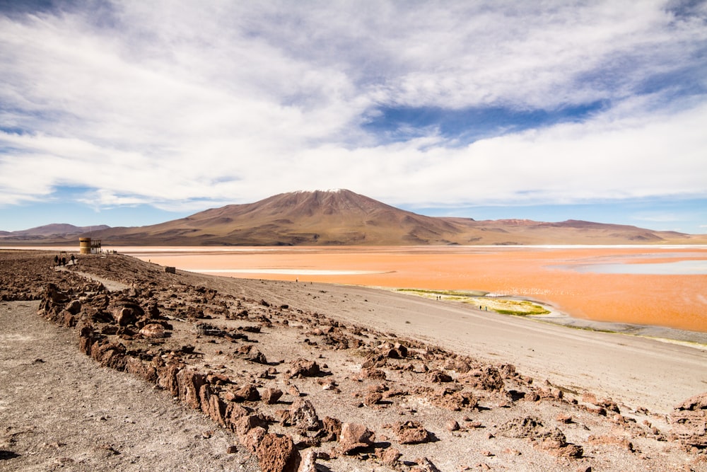 a rocky landscape with a body of water in the distance