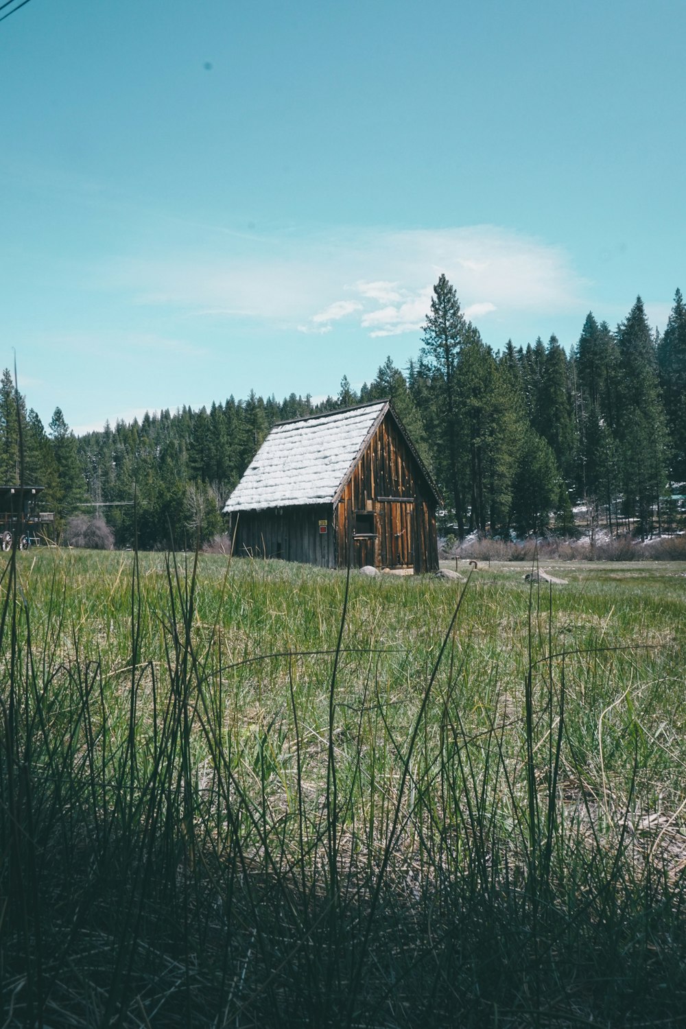 a wooden building in a field