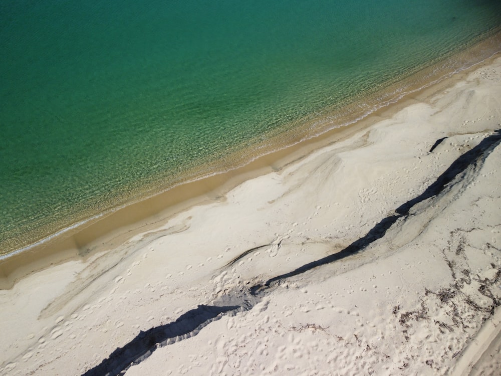 a sandy beach with a body of water in the background