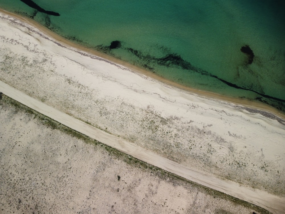 a sandy beach with a body of water in the background