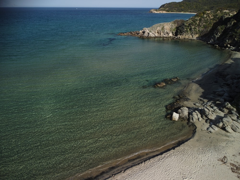 a rocky beach with blue water