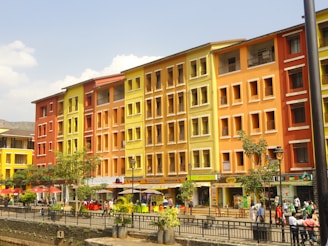 A lively mixed-use development with people enjoying green rooftop terraces and streets filled with shops and cafes.