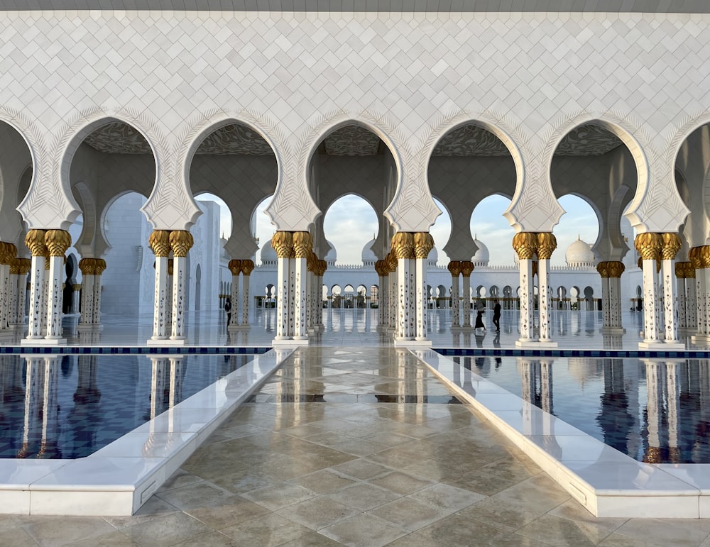 a large building with a pool with Sheikh Zayed Mosque in the background