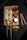 A wooden board holds two skewers of cooked chicken kabobs garnished with herbs. Accompanying the skewers are three small bowls containing sauces: a red sauce, a green chutney with chili flakes, and a white yogurt-based dip. Freshly cut lime, slices of green pepper, shredded cabbage, and other greens are scattered around the board, adding a fresh touch.