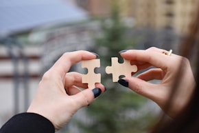 a few hands holding a small white object