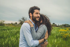 a man hugging a woman in a field