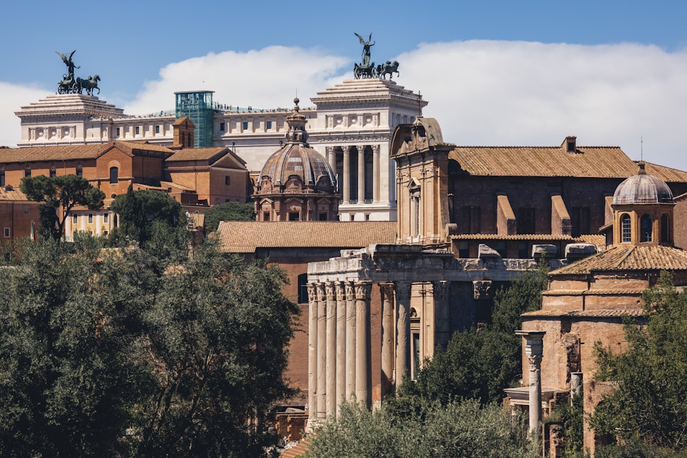 a large building with a statue on top with Roman Forum in the background