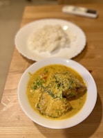 A steaming bowl of fish curry with rice.