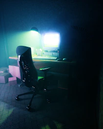 A dimly lit vintage computer desk with a flickering CRT monitor showing pixelated horror game graphics.