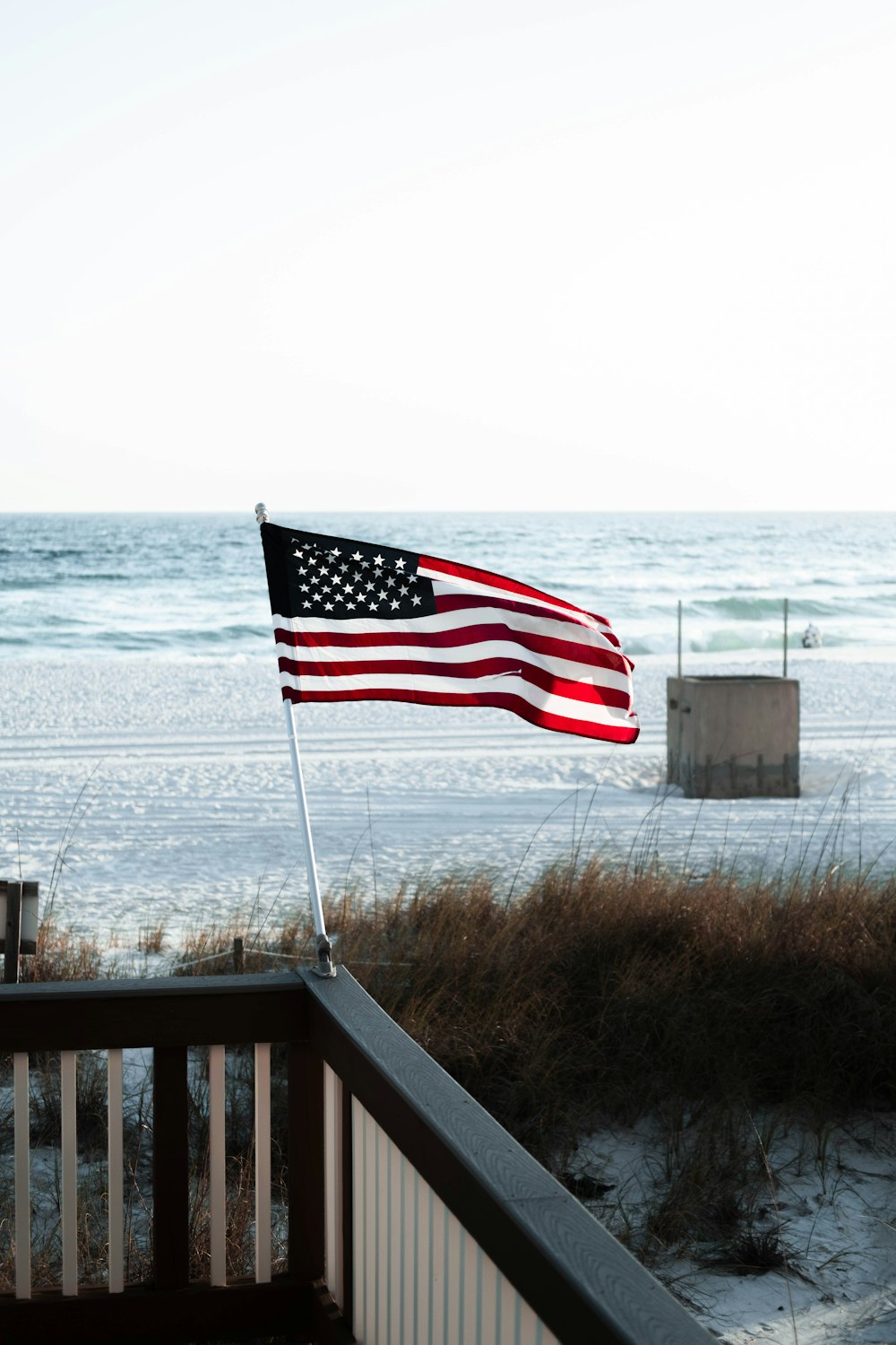 a flag on a railing by the ocean