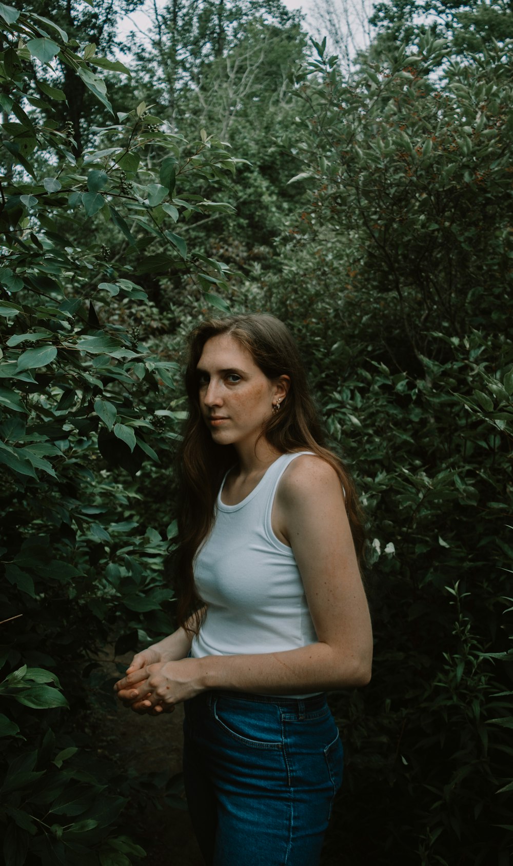 a woman standing in front of a bush