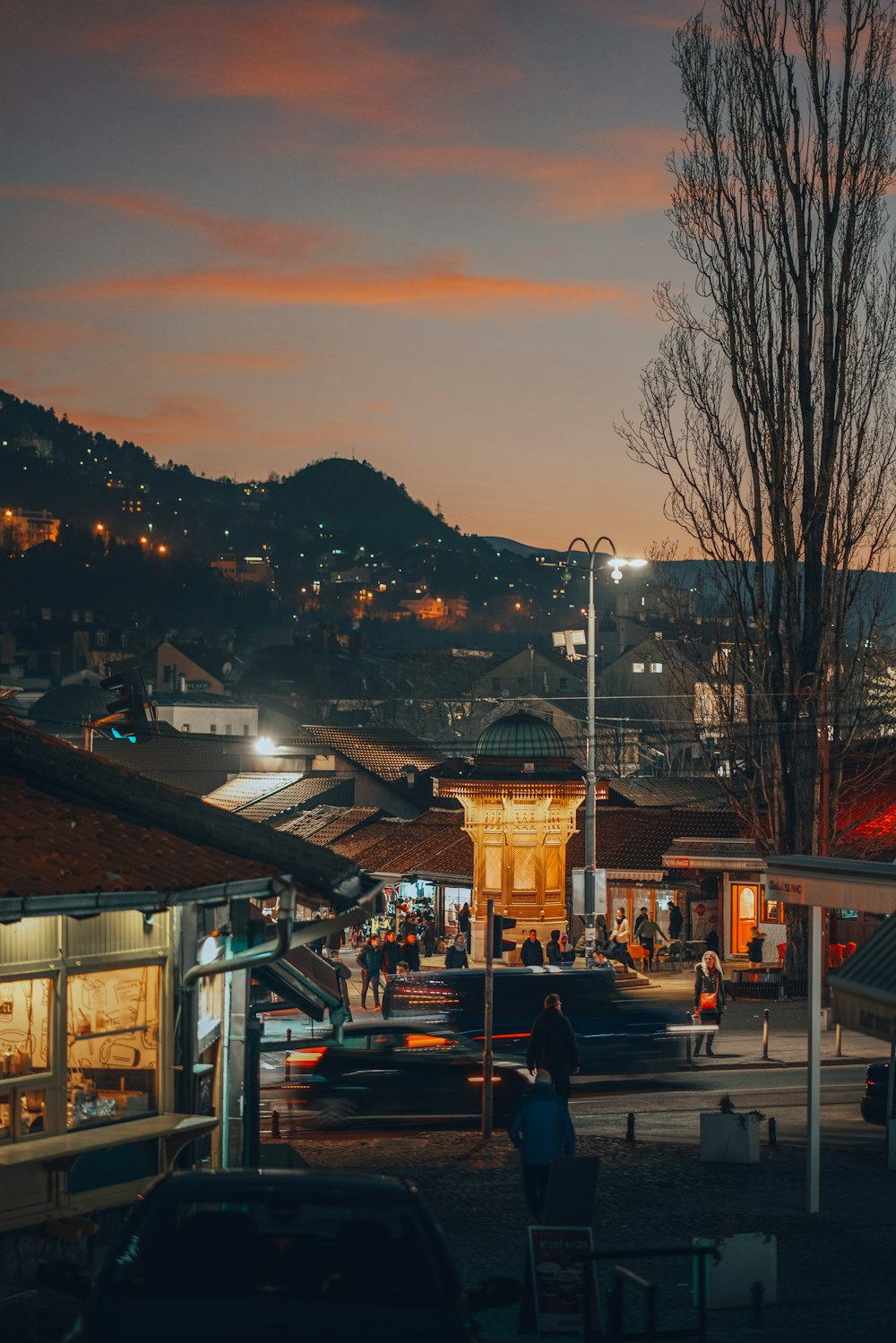 a group of people walking around a town at night