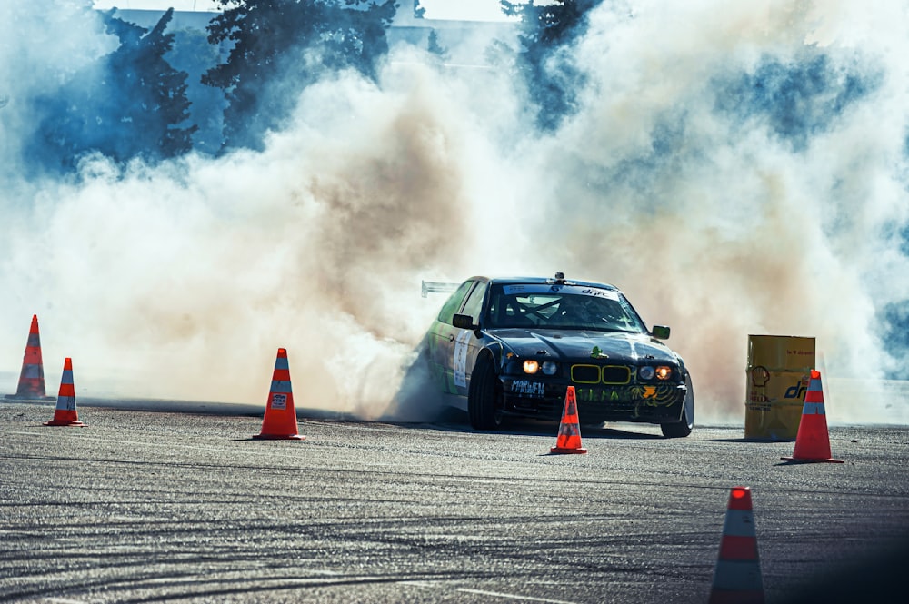 a race car driving around an orange and white cones