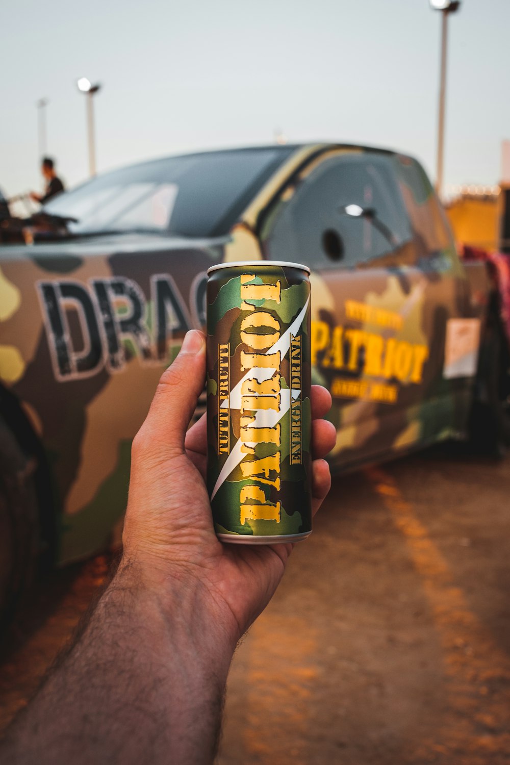 a hand holding a can of beer