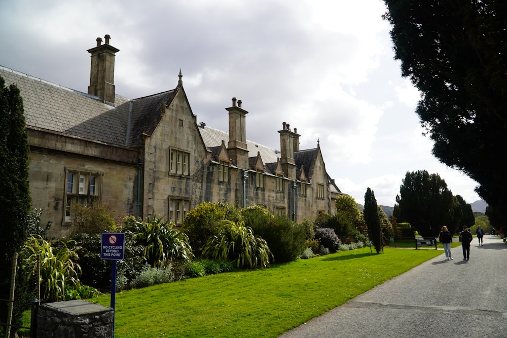 a large building with a lawn and trees in front of it