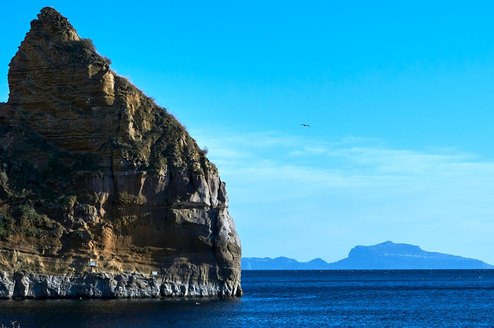 a cliff with a plane flying over it