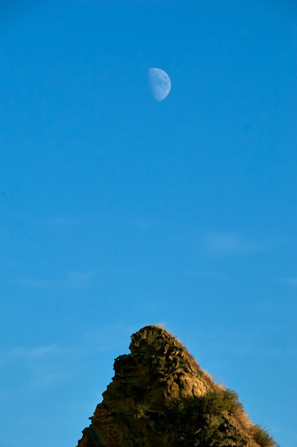 a mountain with the moon in the sky