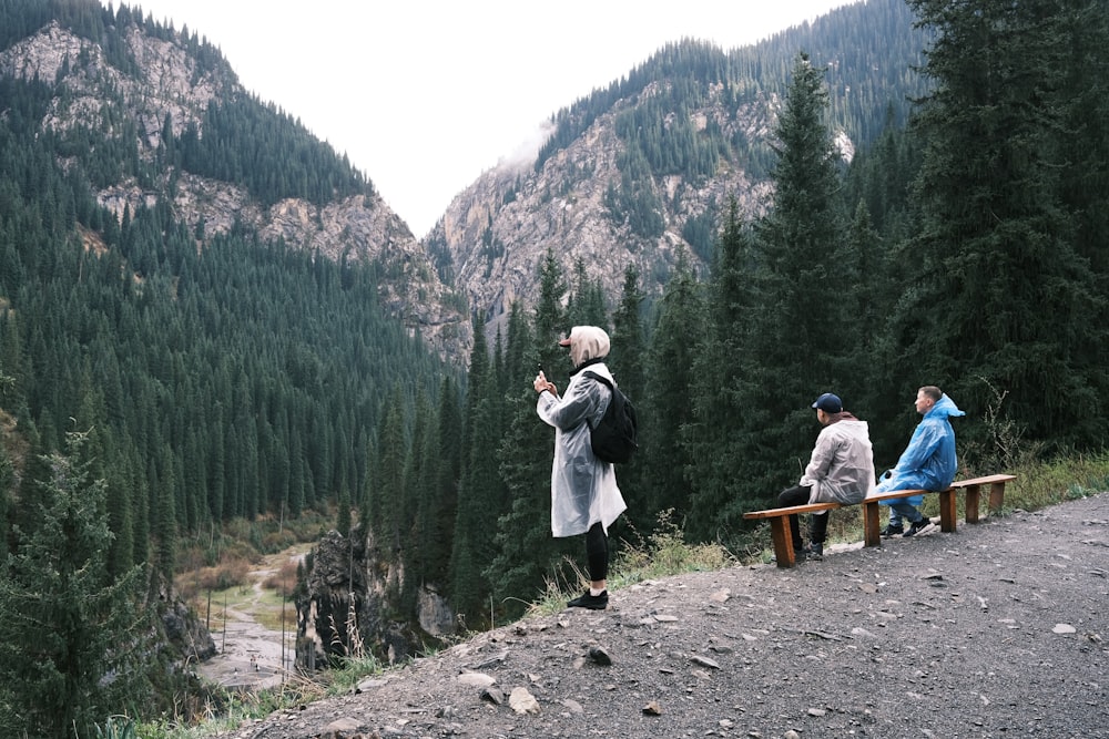 a group of people sitting on a bench in a forest