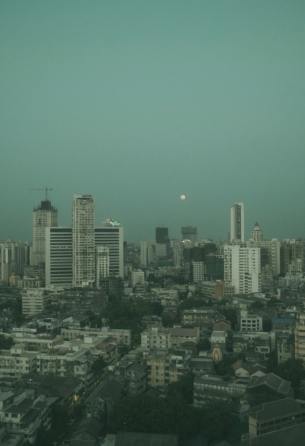 a city with a moon in the sky