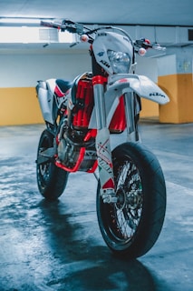 A modern superbike parked next to a classic motorcycle in a garage.