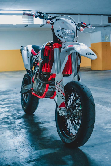 A sleek red Harley-Davidson motorcycle parked against a clean white wall with subtle red accents.