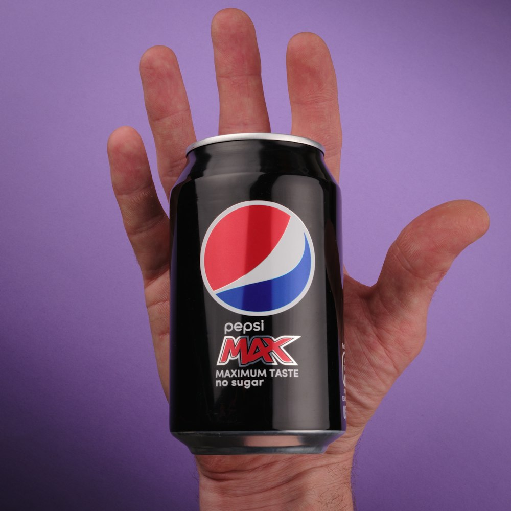 a hand holding a black can