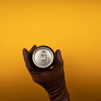 Close-up of a hand holding a cold Pepsi can with condensation droplets.