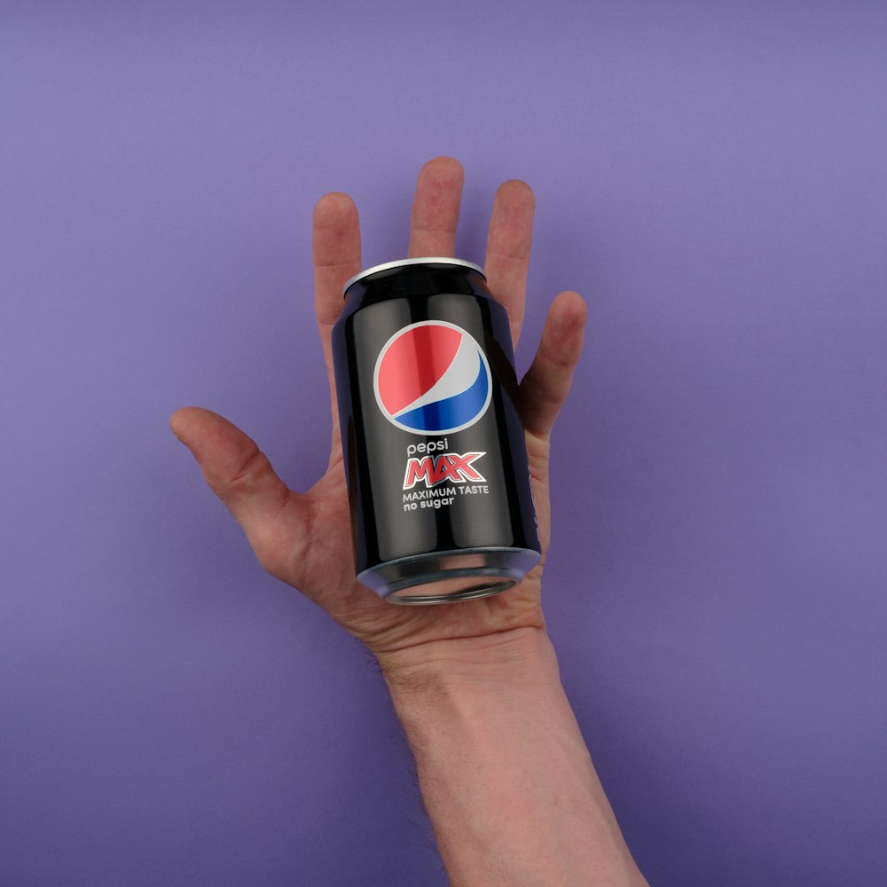 a hand holding a can