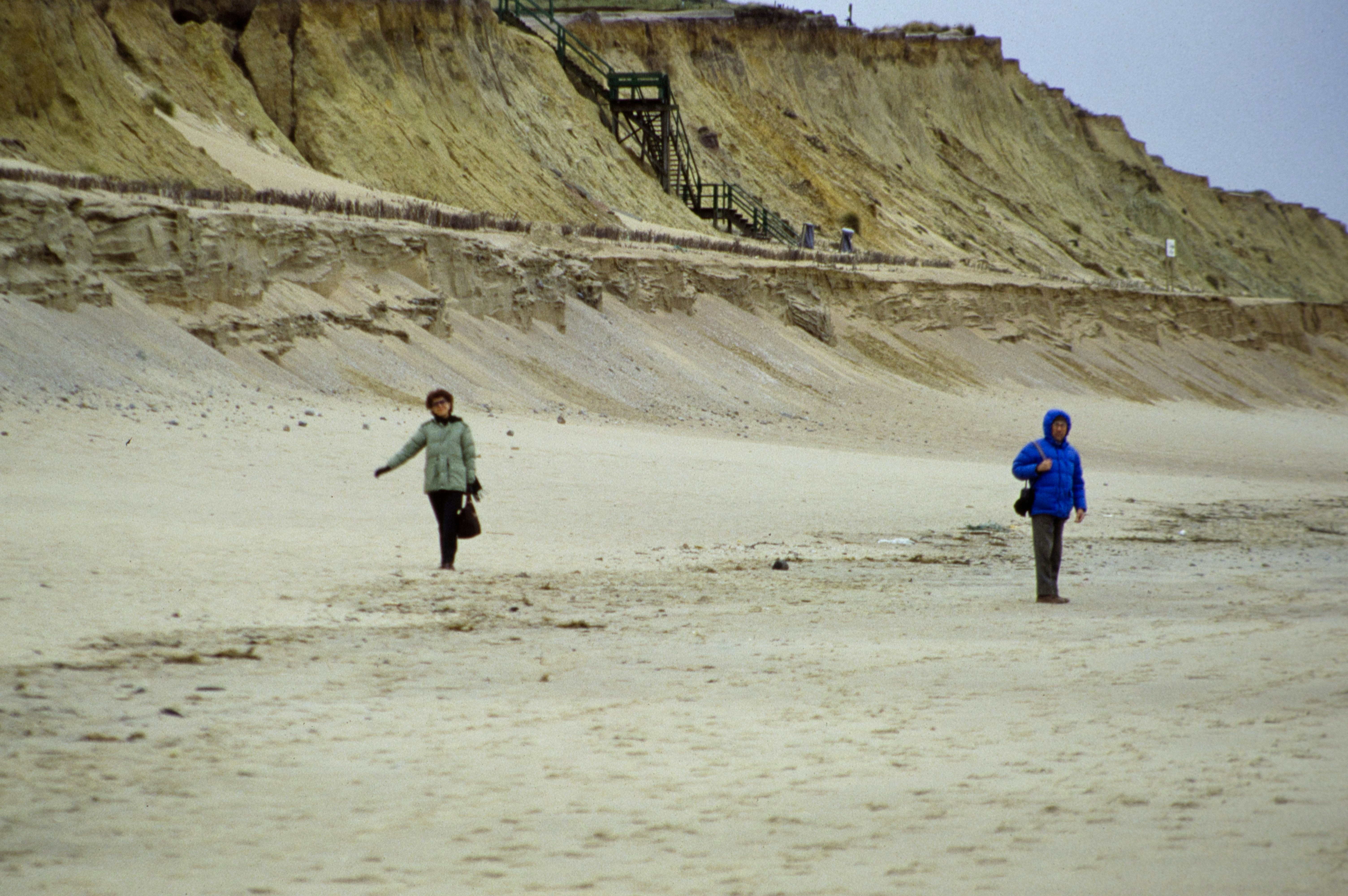 two people walking on a beach