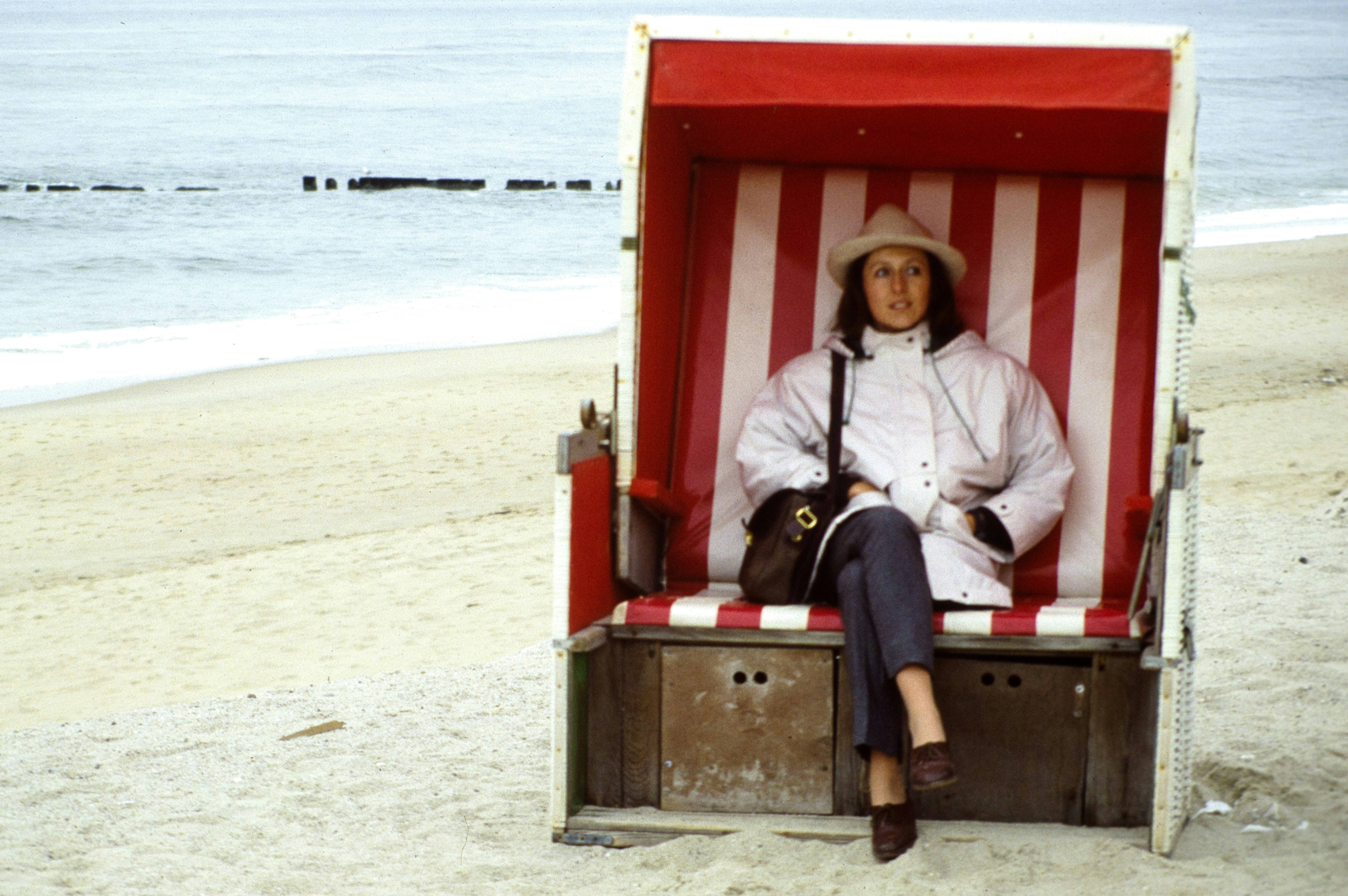 a person sitting in a red box on a beach
