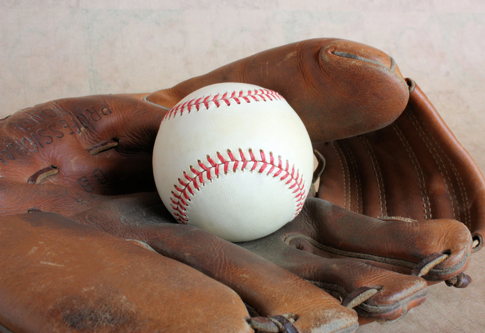 Leather baseball glove holding a baseball