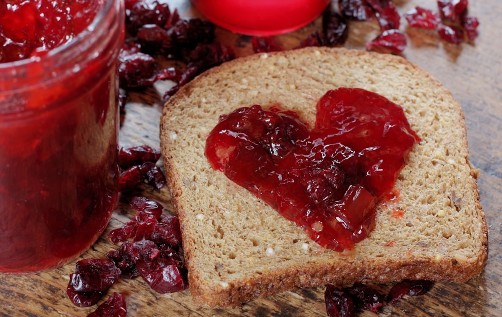 un morceau de pain avec de la confiture et de la confiture dessus