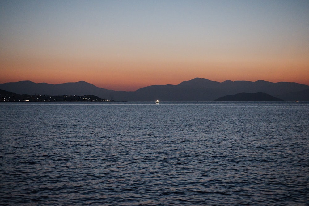 a body of water with mountains in the background